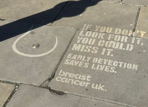 Breast shape with text jet washed on grey pavement