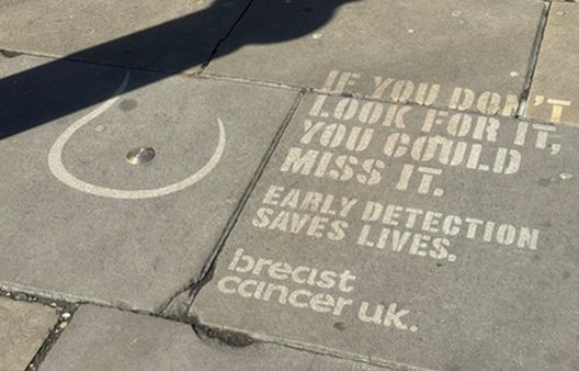 Breast shape with text jet washed on grey pavement