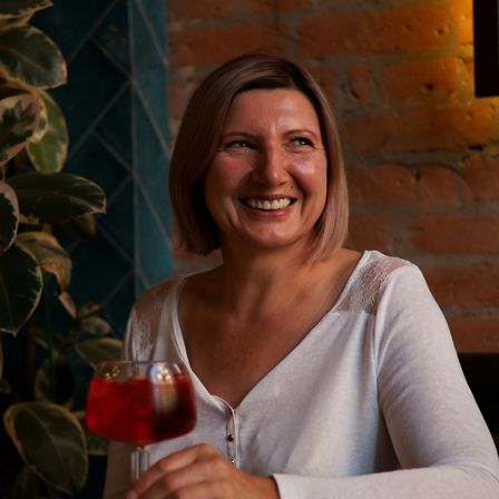 Woman smiling holding mocktail in a bar