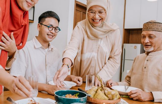 Muslim family gathered around the dinner table smiling