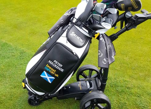 Black and white golf clubs on putting green with logos on side
