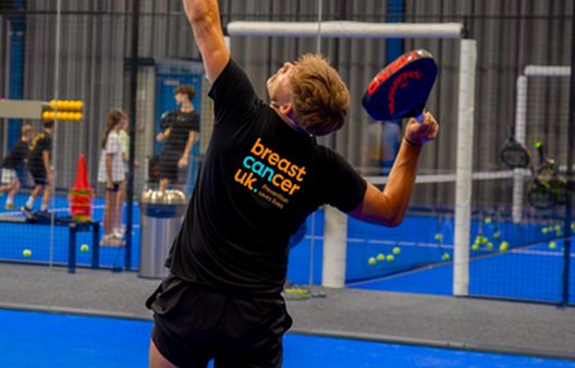 Action shot of young man serving on padel court