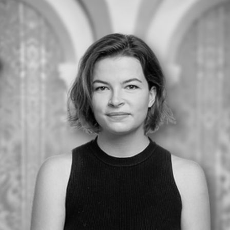 Woman with short brunette hair in black vest in a black and white headshotGrace Bugden
