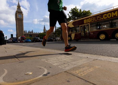 man running past wording and breast shape on pavement