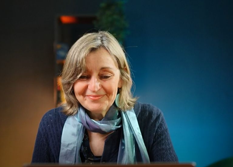 woman with short hair and blue scarf Looking at laptop