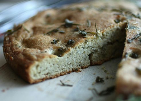 Focaccia with rosemary bread and slice taken out of it