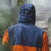 Person in navy raincoat in the rain
