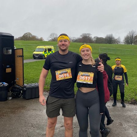 Tow people in blakc clothing and headbands who have finished a tough mudder